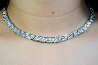 Silver zirconia necklace on a woman's neck with a neutral background