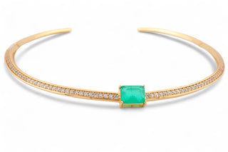Gold choker necklace with zirconias and a green gemstone in the middle with white background