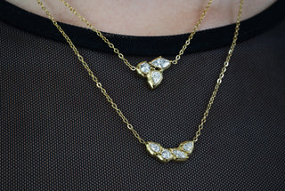 Two gold plated necklaces with zirconia pendants on a neck
