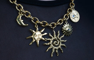 Trendy gold-plated stainless-steel charm necklace on a white background