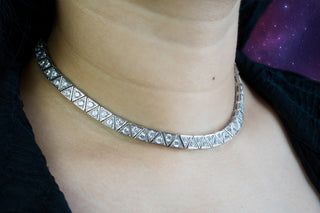 Silver zirconia necklace on a woman's neck with a neutral background