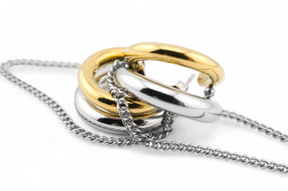 Pair of gold and silver stainless steel hoop earrings with a small chain in the middle