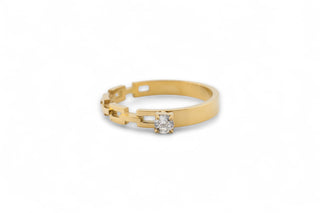 Gold band ring with a white gemstone on a white background