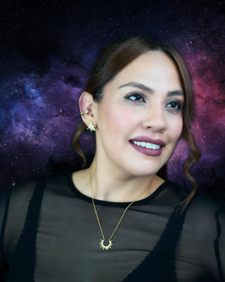 Woman wearing sterling silver stud earrings and star shaped gold-plated necklace