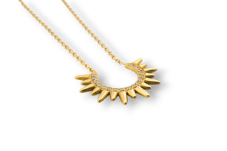Gold necklace with a sunburst trendy design on a white background