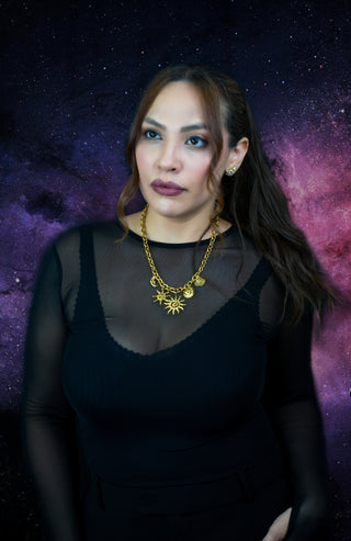 Woman wearing trendy gold-plated stainless-steel charm necklace on a starry background