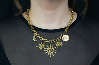 Woman wearing trendy gold-plated stainless-steel charm necklace on a white background